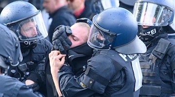 Polizisten nehmen einen Dynamofan vor dem Stadion fest. Foto: Robert Michael/dpa-Zentralbild/dpa