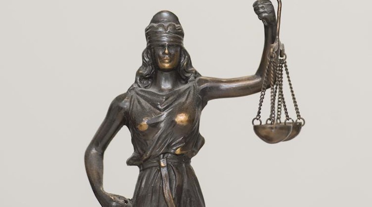 Eine Figur «Justitia» steht auf einem Schreibtisch. Foto: picture alliance / dpa