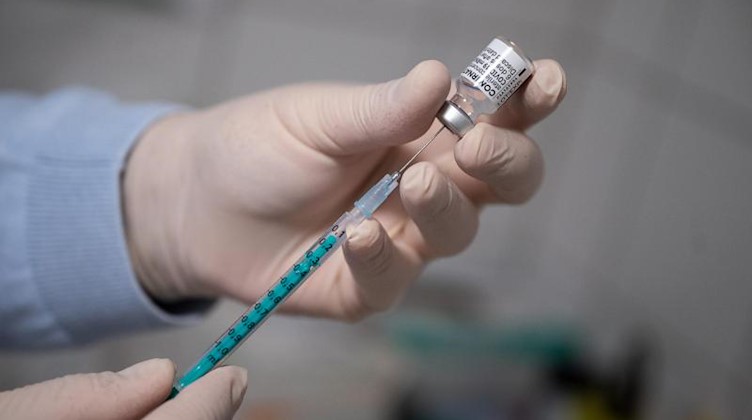 Ein Arzt zieht in einer Hausarztpraxis eine Spritze mit dem Impfstoff von Pfizer/Biontech auf. Foto: Sebastian Gollnow/dpa/Archivbild