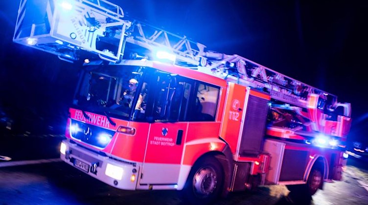 Ein Drehleiterwagen der Feuerwehr mit Blaulicht. Foto: Marcel Kusch/dpa/Symbolbild
