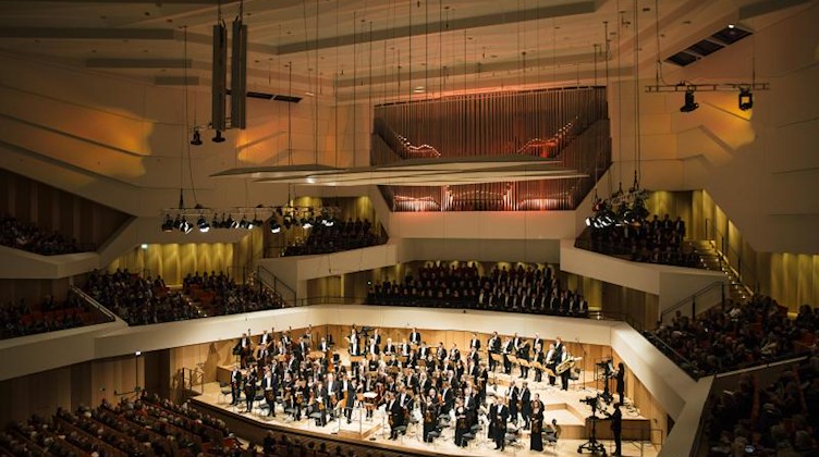 Musiker der Dresdner Philharmonie stehen auf der Bühne des Kulturpalastes. Foto: Oliver Killig/dpa-Zentralbild/dpa/Archiv