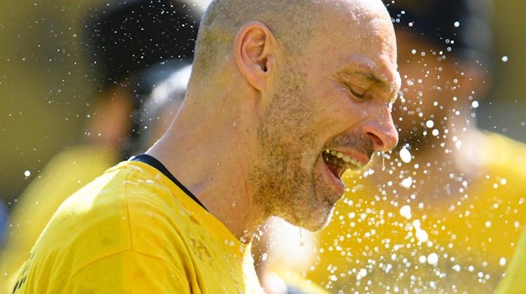 Dynamos Trainer Alexander Schmidt wird mit Bier übergossen. Foto: Robert Michael/dpa-Zentralbild/dpa/Archivbild