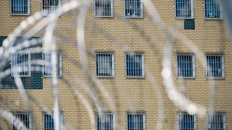Blick durch den Stacheldrahtzaun vor einer Justizvollzugsanstalt. Foto: Peter Steffen/dpa/Symbolbild
