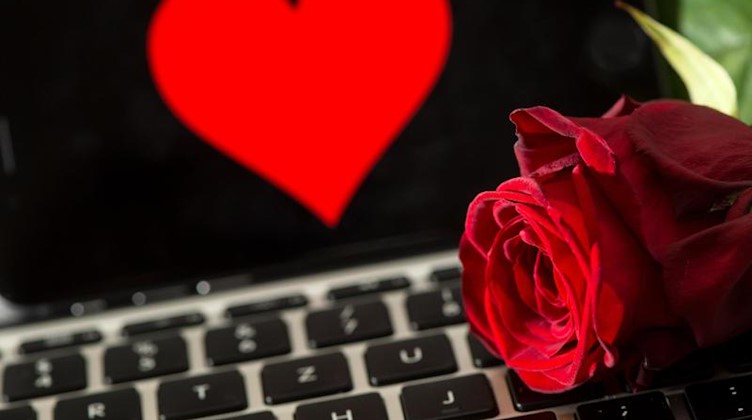 Eine Rose liegt auf einer Computertastatur. Foto: Sven Hoppe/dpa/Symbolbild