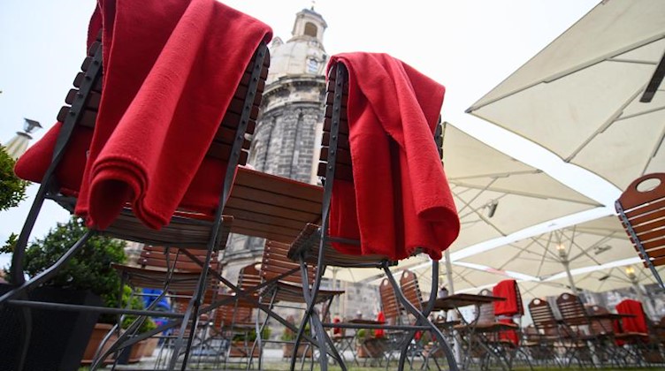 Rote Decken liegen auf Stühlen der Außengastronomie eines Restaurants. Foto: Robert Michael/dpa-Zentralbild/dpa