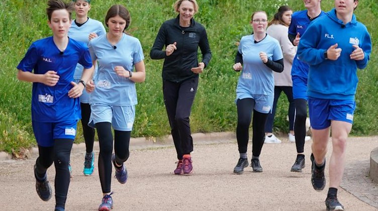 Heike Drechsler (M) trainiert Jugendliche aus der Crosslauf-Doku «RUN4U #lauf» des Mitteldeutschen Rundfunks (MDR) am Völkerschlachtdenkmal in Leipzig. Foto: Peter Endig/dpa-Zentralbild/dpa