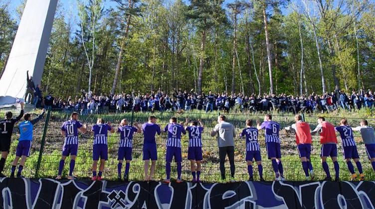Aues Spieler feiern nach dem Spiel mit Fans. Foto: Robert Michael/dpa-Zentralbild/dpa