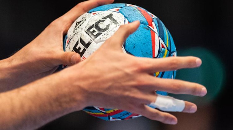 Ein Ball in der Hand eines Spielers. Foto: Robert Michael/dpa/Symbolbild