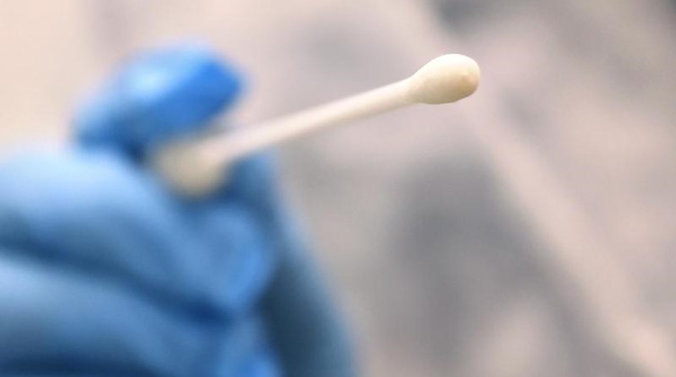 Ein Arzt hält einen Tupfer, mit dem ein Abstrich für einen Coronatest gemacht wird. Foto: Karl-Josef Hildenbrand/dpa/Symbolbild