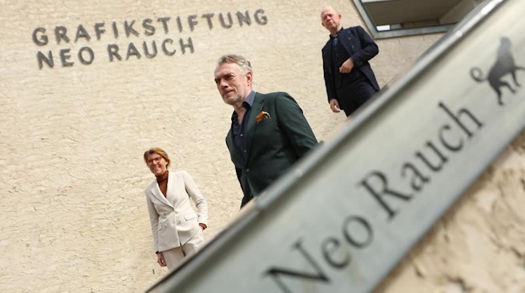 Journalistin und Moderatorin Bettina Böttinger (l-r), der Künstler Neo Rauch und der Galerist Gerd Harry Lybke stehen vor der Grafikstiftung Neo Rauch. Foto: Matthias Bein/dpa-Zentralbild/dpa/Archivbild