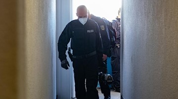 Bundespolizisten gehen bei einer Razzia gegen Schleuser durch einen Hausflur. Foto: Paul Zinken/dpa-Zentralbild/dpa