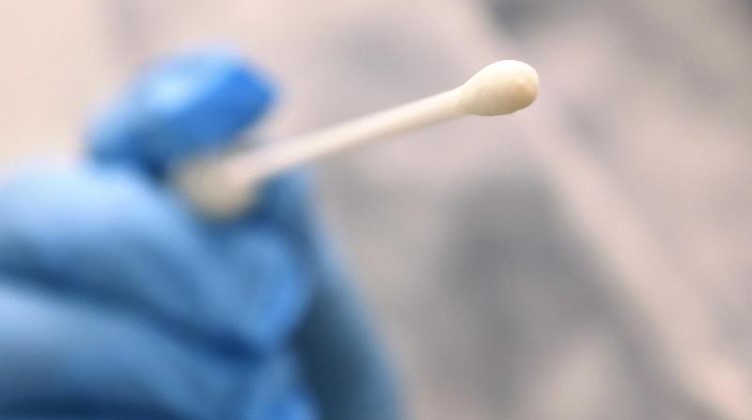 Ein Arzt hält einen Tupfer, mit dem ein Abstrich für einen Coronatest gemacht wird. Foto: Karl-Josef Hildenbrand/dpa/Symbolbild