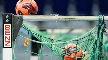 Spielbälle liegen im Netz eines Handball-Tors. Foto: Uwe Anspach/dpa/Symbolbild