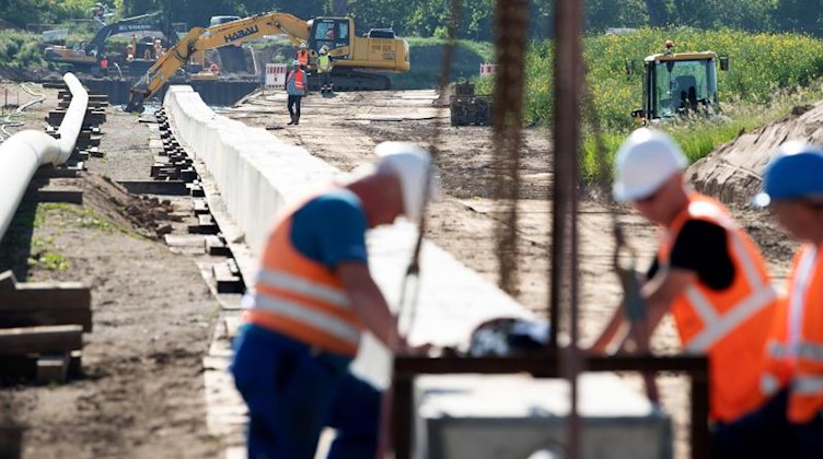 Mitarbeiter der Ontras Gastransport GmbH arbeiten bei der Erneuerung der Ferngasleitung Lauchhammer-Strehla, am Ufer der Elbe. Foto: Sebastian Kahnert/dpa-Zentralbild/dpa