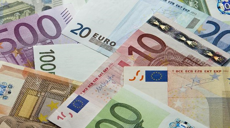 Zahlreiche Euro-Banknoten liegen auf einem Haufen. Foto: Daniel Reinhardt/dpa/Illustration