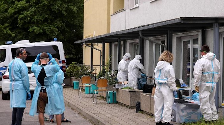 Mitarbeiter des Gesundheitsamts bereiten Corona-Tests für die Bewohner eines Hochhauses in Dresden vor. Foto: Tino Plunert/dpa-Zentralbild/dpa