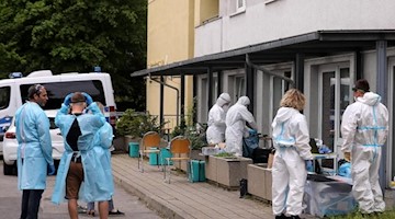 Mitarbeiter des Gesundheitsamts bereiten Corona-Tests für die Bewohner eines Hochhauses in Dresden vor. Foto: Tino Plunert/dpa-Zentralbild/dpa