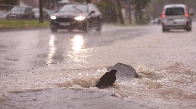 Bei starkem Regen ist eine Straße überflutet. Foto: Matthias Bein/dpa-Zentralbild/dpa/Symbolbild