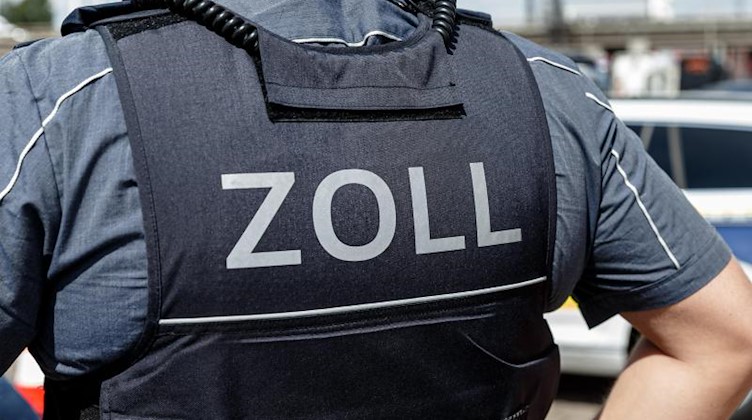 Ein Beamter trägt während seines Dienstes eine Schutzweste mit der Rückenaufschrift "Zoll". Foto: Markus Scholz/dpa/Symbolbild
