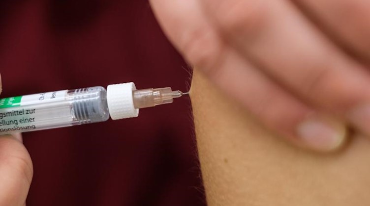 Eine Arzthelferin impft eine Patentin mit einer Spritze. Foto: Ole Spata/dpa/Symbolbild