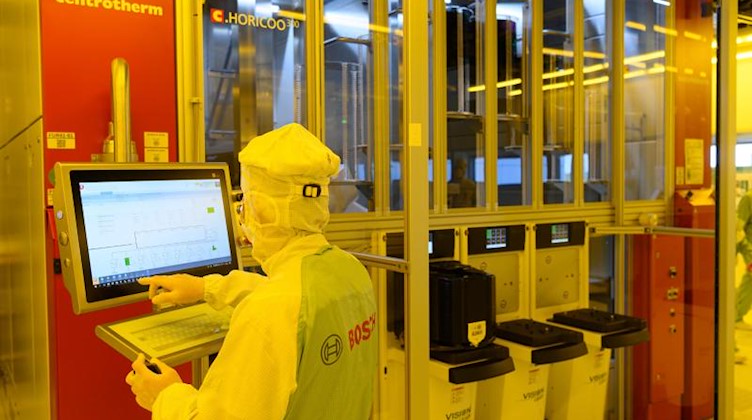 Ein Mitarbeiter steht in der neuen Halbleiterfabrik von Bosch an einer Maschine. Foto: Robert Michael/dpa-Zentralbild/dpa/Symbolbild