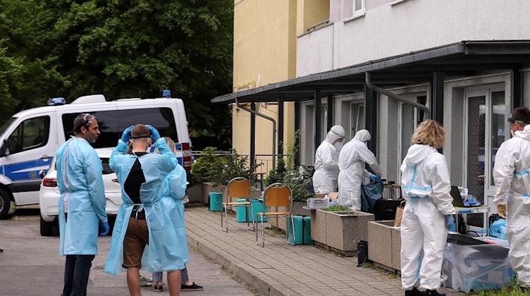 Mitarbeiter des Gesundheitsamts bereiten Coronatests für die Bewohner eines Hochhauses vor. Foto: Tino Plunert/dpa-Zentralbild/dpa/Archivbild