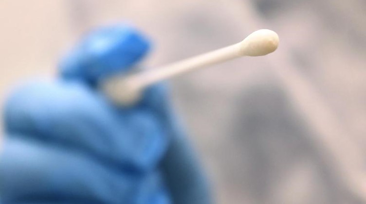 Ein Arzt hält einen Tupfer, mit dem ein Abstrich für einen Coronatest gemacht wird. Foto: Karl-Josef Hildenbrand/dpa/Symbolbild