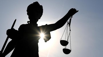 Eine Statue der Justitia mit einer Waage und einem Schwert in ihren Händen. Foto: Arne Dedert/dpa/Symbolbild