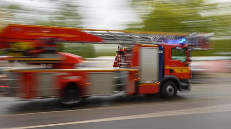Ein Feuerwehrfahrzeug mit Drehleiter fährt zu einem Einsatz. Foto: Robert Michael/dpa-Zentralbild/ZB/Symbolbild