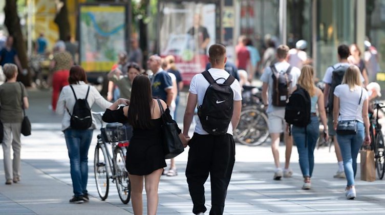 Passanten gehen auf der Einkaufsstraße Prager Straße an den Geschäften entlang. Foto: Sebastian Kahnert/dpa-Zentralbild/dpa