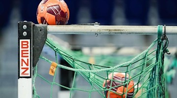 Spielbälle liegen im Netz eines Handball-Tors. Foto: Uwe Anspach/dpa/Symbolbild