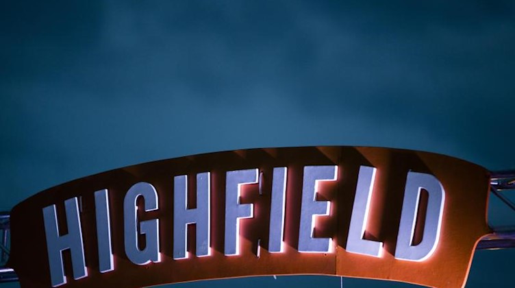 Dunkle Regenwolken ziehen hinter dem Schild «Highfield-Festival» auf. Foto: Alexander Prautzsch/ZB/dpa/Archivbild