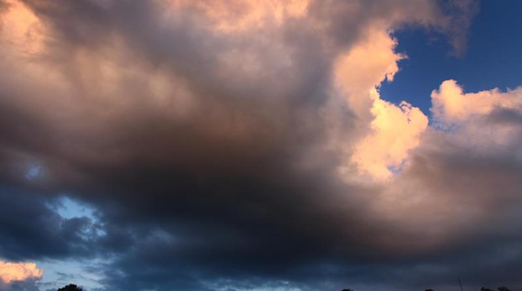 Wolken leuchten im Abendlicht. Foto: Karl-Josef Hildenbrand/dpa