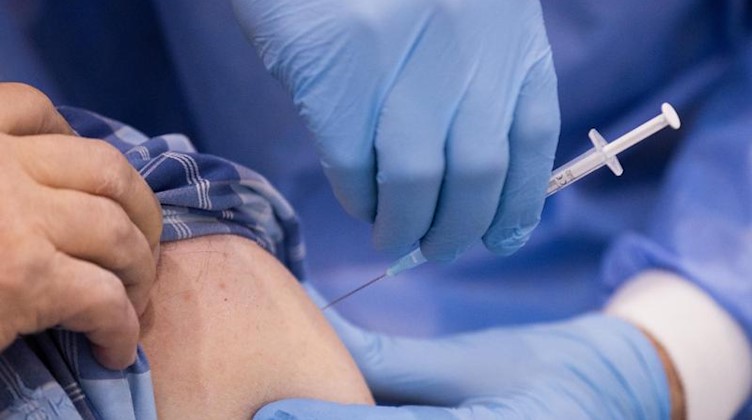 Ein Arzt impft einen Mann. Foto: Rolf Vennenbernd/dpa/Symbolbild
