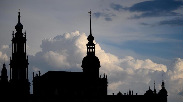 Wolken ziehen am Abend hinter der Altstadt mit dem Ständehaus (l-r), der Hofkirche, dem Hausmannsturm und dem Residenzschloss auf. Foto: Robert Michael/dpa-Zentralbild/dpa