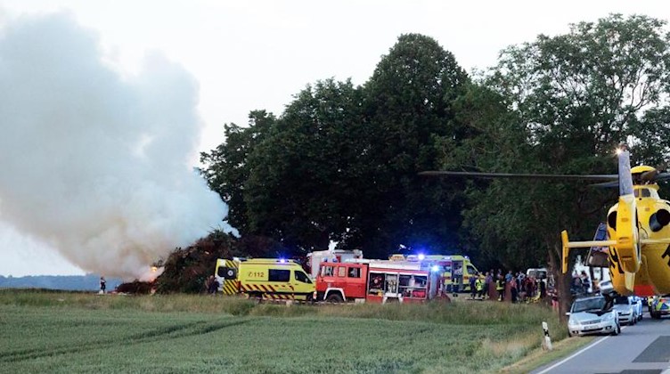 Das Feuer brennt noch, als einer von vier Rettungshubschraubern Verletze ins Krankenhaus fliegt. Foto: Rocci Klein/dpa