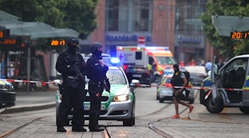 Polizisten und Rettungskräfte stehen in der Innenstadt. Foto: Karl-Josef Hildenbrand/dpa
