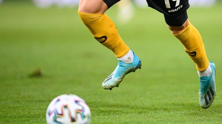 Ein Fußballspieler spielt den Ball. Foto: Robert Michael/dpa-Zentralbild/dpa/Symbolbild