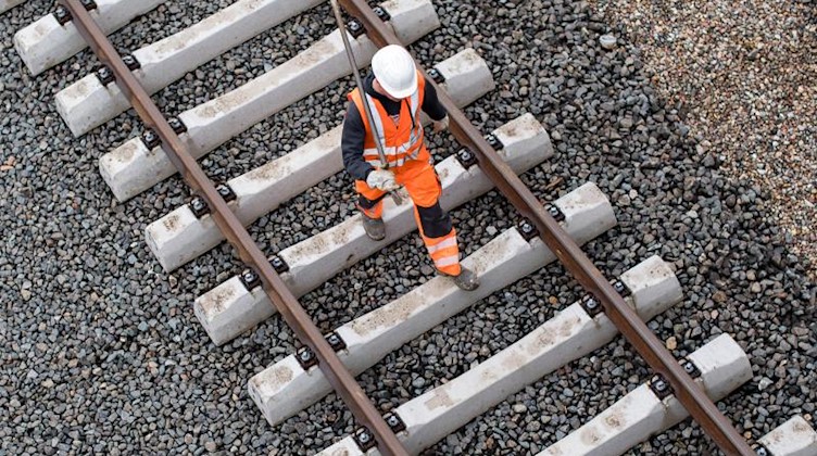 Ein Arbeiter geht über eine noch nicht fertige Gleisanlage der Bahn. Foto: Lukas Schulze/dpa/Archivbild