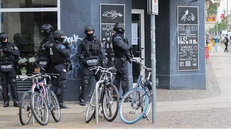 Polizisten stehen in Leipzig an einer Hausecke. Foto: Tobias Junghannß/dpa-Zentralbild/dpa