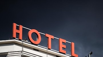 Dunkle Wolken ziehen über einem Hotel hinweg. Foto: Christoph Schmidt/dpa/Symbolbild