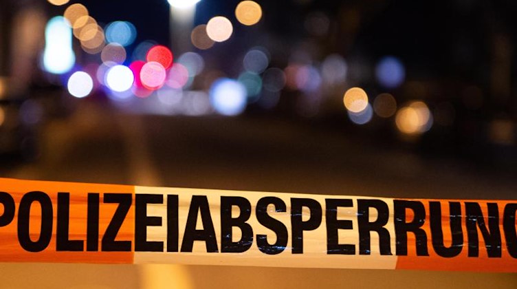 Ein Einsatzort der Polizei ist mit Flatterband abgesperrt. Foto: Christophe Gateau/dpa/Symbolbild
