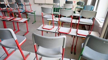 Stühle stehen in einer Schule auf den Tischen. Foto: Kay Nietfeld/dpa/Symbolbild