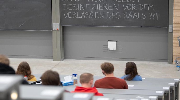 Studierende mit Mund- und Nasenmaske sitzen in einem Hörsaal. Foto: Sebastian Gollnow/dpa/Symbolbild