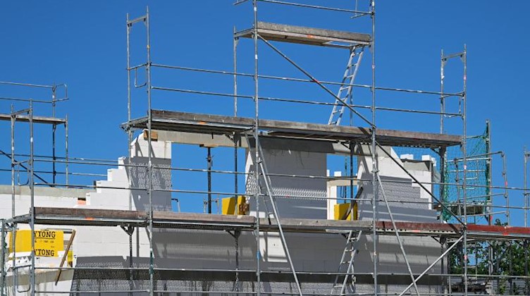 Ein Baugerüst steht an der Fassade eines im Bau befindlichen Einfamilienhauses. Foto: Soeren Stache/dpa-Zentralbild/dpa/Archivbild
