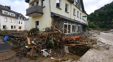 Schutt und Holz liegen aufgetürmt vor einem Haus in dem Ort im Kreis Ahrweiler am Tag nach dem Unwetter mit Hochwasser. Foto: Thomas Frey/dpa