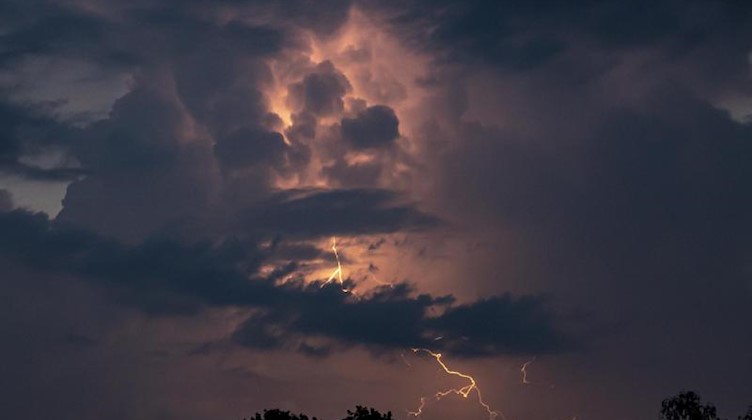 Ein Blitz hellt die dunklen Wolken auf. Foto: Fabian Sommer/dpa/Symbolbild
