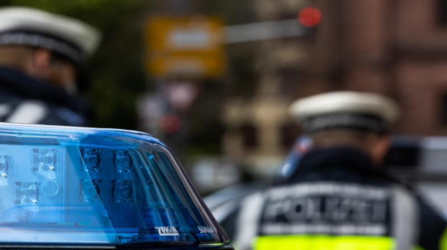 Zwei Polizeibeamte stehen zwischen Einsatzfahrzeugen. Foto: Philipp von Ditfurth/dpa/Symbolbild