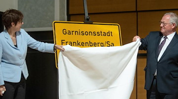 Bundesverteidigungsministerin Kramp-Karrenbauer und Frankenbergs Bürgermeister Firmenich enthüllen ein Ortseingangsschild der Stadt Frankenberg mit dem Namenszusatzes «Garnisonsstadt». Foto: Hendrik Schmidt/dpa-Zentralbild/dpa