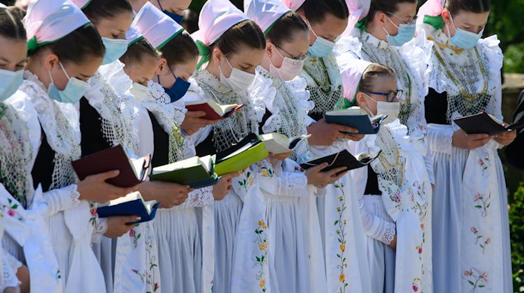 Die Druschki, die sorbischen Brautjungfern, singen in ihren Trachten zu Fronleichnam. Foto: Robert Michael/dpa-Zentralbild/dpa/Archivbild